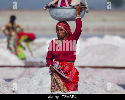 SAMBHAR, INDIEN - November 19, 2012: Porträt der indischen Frau mittleren Alters trägt ein Becken mit Instrumenten auf den Kopf. Frau raucht, während der b Stockfoto