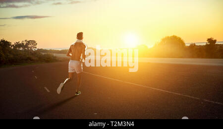 Junge Sportler, die auf Asphalt. Mixed Media Stockfoto