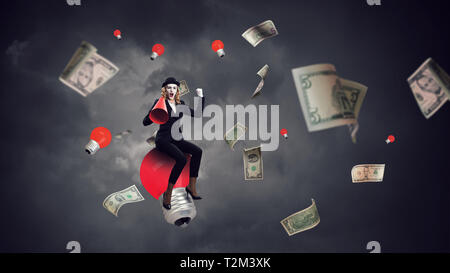 Mime-Frau im schwarzen Anzug sitzt auf Ballon. Mixed Media Stockfoto