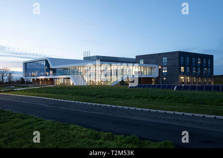 In der breiten Ansicht der Fassade in der Abenddämmerung. Menai Science Parc, Bangor, Großbritannien. Architekt: FaulknerBrowns, 2019. Stockfoto