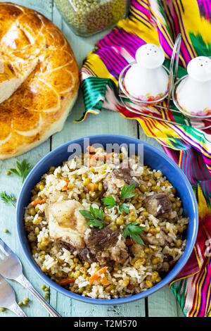 Die arabische Küche. Veranstaltungen Ramadan. Im Nahen und Mittleren Osten Mashkichiri (Brei von Reis, Rind und mung Bean) auf hölzernen Tisch. Stockfoto