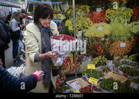 Eine Frau kauft einen Blumenstrauß an einem der Blume Verkaufsstände in Amsterdam. Stockfoto