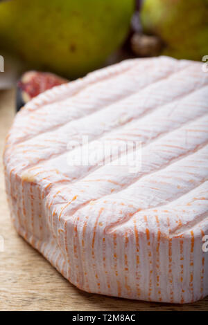 Rundes Stück französischer Käse Fleur Rouge aus Kuhmilch hergestellt als Dessert serviert mit frischen Feigen und Birnen Nahaufnahme Stockfoto