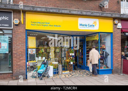 Man Walking in Marie-curie-Hospiz Charity Shop im Dorf Knowle in der Nähe von Solihull, West Midlands Stockfoto