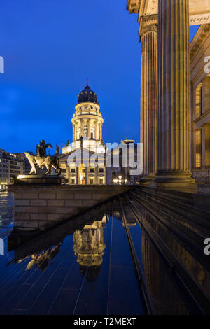 Leuchtet die Neue Kirche (Deutscher Dom, Deutsche Kirche oder Deutscher Dom) und Vorderseite des Konzerthauses Berlin am Gendarmenmarkt in Berlin in der Abenddämmerung. Stockfoto