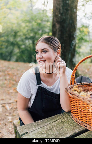 Frau sammeln von Kastanien, Rezzago, Lombardei, Italien Stockfoto