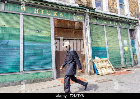 Mann (Bewegung verschwommen) vor der Closed Shop im Golborne Road, Notting Hill. Stockfoto