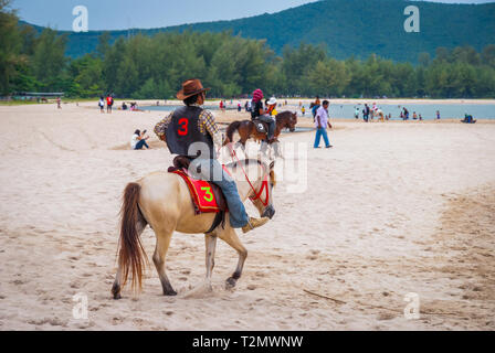 Songkhla, Thailand - Okt 2015: der Mann, der ein Pferd Reiten am populären Samila Strand, Thailand Stockfoto