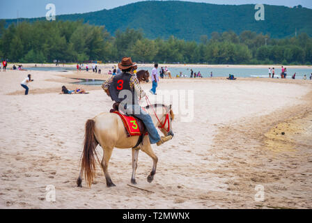 Songkhla, Thailand - Okt 2015: der Mann, der ein Pferd Reiten am populären Samila Strand, Thailand Stockfoto