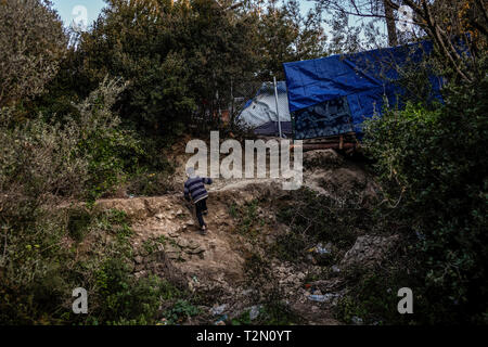 Vathy, Griechenland. 25 Mär, 2019. Ein Junge klettert ein Gefälle in einem Flüchtlingslager auf der griechischen Insel Samos. Rund 4500 Flüchtlinge und Migranten leben hier. Sie wurden gezwungen, um die Insel zu vereinbaren so genannte Hotspot, einem ehemaligen Gefängnis, das sich hinter der Stahl Zäune mit Stacheldraht bewehrt, bietet Platz für 650 Personen. Credit: Angelos Tzortzinis/dpa/Alamy leben Nachrichten Stockfoto