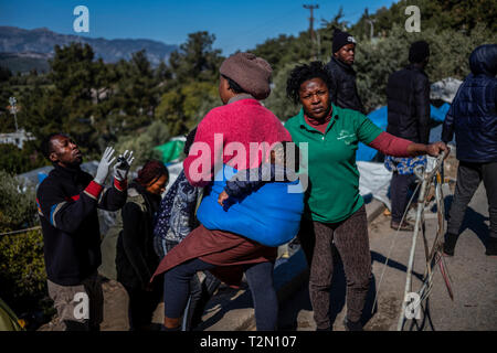 Vathy, Griechenland. 25 Mär, 2019. Flüchtlinge sprechen im Flüchtlingslager auf der griechischen Insel Samos. Rund 4500 Flüchtlinge und Migranten leben hier. Sie wurden gezwungen, um die Insel zu vereinbaren so genannte Hotspot, einem ehemaligen Gefängnis, das sich hinter der Stahl Zäune mit Stacheldraht bewehrt, bietet Platz für 650 Personen. Credit: Angelos Tzortzinis/dpa/Alamy leben Nachrichten Stockfoto