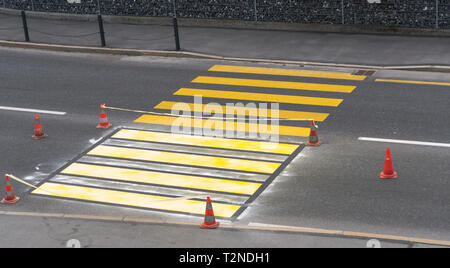 Abgesperrt frisch Fußgängerzone Zebrastreifen mit leuchtend gelben Farbe für Straße und Verkehr Sicherheit in einem Schweizer Dorf gemalt Stockfoto