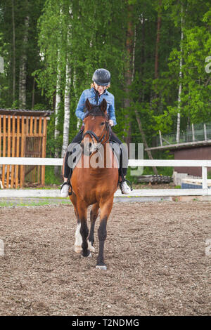 Reitunterricht, kaukasische Mädchen im Teenageralter und einem Pferd auf manege, vertikale Foto Stockfoto