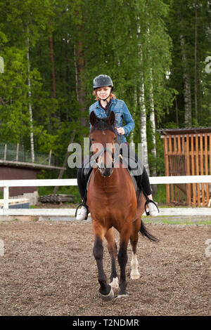 Reitunterricht, Teenager kaukasische Mädchen reitet ein Pferd reiten, vertikale Foto Stockfoto