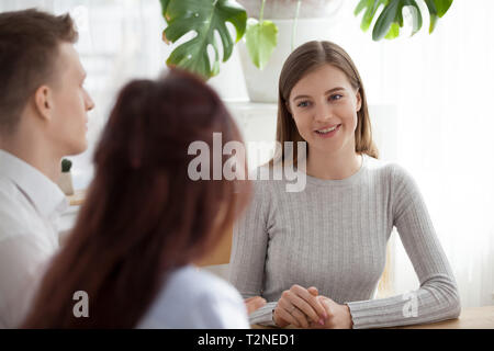 Direktor und Berater Befragung von neuen Kandidaten Stellenausschreibung Unternehmen am Schreibtisch im Büro Konferenzraum sitzen. Junge lächelnde Frau, die Antworten auf die Fragen gehen Stockfoto