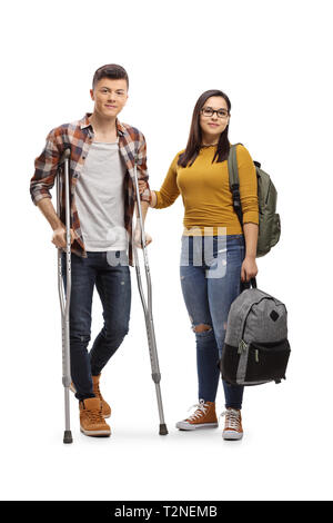 In voller Länge Porträt einer männlichen Kursteilnehmer mit Krücken und eine Studentin mit einem Rucksack auf weißem Hintergrund Stockfoto