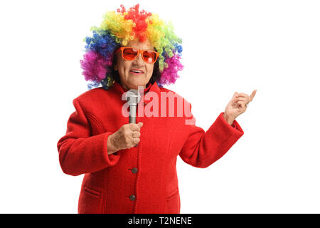 Ältere Frau mit einem Clown Perücke und ein Mikrofon auf weißem Hintergrund Stockfoto