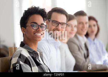 Fünf glückliche zuversichtlich Erfolgreiche gemischtrassiges Team lächelnd zusammen im Büro Sitzungssaal. Unternehmen wird von einem schwarzen Führer boss woman Fokus auf der Leitung Stockfoto