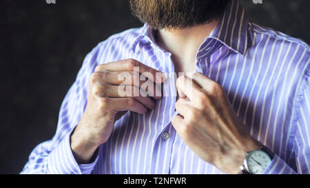 Nahaufnahme des Jungen bärtigen Mann in Armbanduhr indem Er Seinen gestreiften Hemd Fertig zu gehen. Werden zu spät zur Arbeit, gekleidet in Eile Konzept. Stockfoto