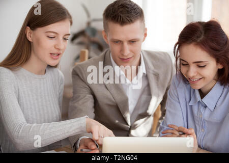 Drei junge Geschäftsleute Kollegen Studenten an einem Tisch sitzen diskutieren neue Creative Business Plan in der Sitzung briefing im Büro. Frau zeigen Poi Stockfoto