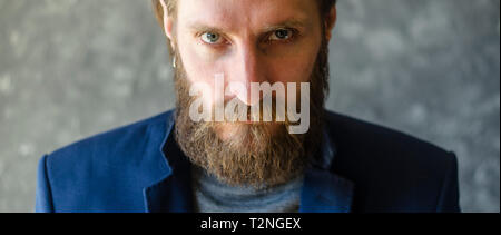 Mode Portrait von bärtigen Mann im blauen Anzug Blazer mit wütend in die Kamera schauen. Stern Konzept Aussehen Stockfoto