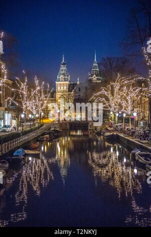 Schöne beleuchtete Bäume säumen die Gracht in Amsterdam das "Venedig des Nordens", die sich auf eine niederländische Geschichte museum Rijksmuseum in Amsterdam, Net führt Stockfoto