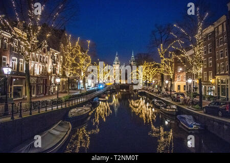 Schöne beleuchtete Bäume säumen die Gracht in Amsterdam das "Venedig des Nordens", die sich auf eine niederländische Geschichte museum Rijksmuseum in Amsterdam, Net führt Stockfoto