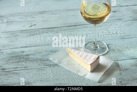 Glas Weißwein mit Brie auf der hölzernen Hintergrund Stockfoto