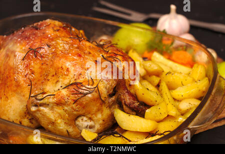 Im Ofen gebackene knusprige Kruste gefüllte Huhn auf einem Teller mit Kartoffeln, Äpfel, Knoblauch Stockfoto