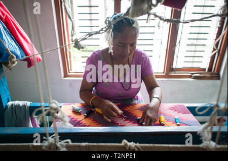 Ein Nepali Frau sticken Seide und Wolle pashmina Schals von Webstuhl, W.F. Nepal, eine nichtstaatliche Organisation, die Beschäftigung von marginalisierten Frauen auf einer gleichberechtigten Basis. Stockfoto