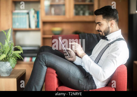 Geschäftsmann mit digitalen Tablette im Sessel Stockfoto