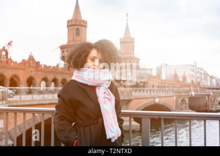 Mitte der erwachsenen Frau in der Schal auf der Oberbaumbrücke, Porträt, Berlin, Deutschland Stockfoto