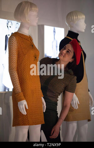 Ein Mitglied des Personals in einem Quant Kleid passt ein Display Modell in der Ausstellung 'Mary Quant', die sich im Victoria und Albert Museum, London, Erscheinen öffnet sich Stockfoto