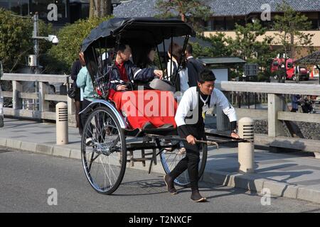 KYOTO, Japan - 17. APRIL 2012: Besucher mit einer Rikscha in Arashiyama, Kyoto, Japan. Arashiyama ist ein national benannten Ort der landschaftlichen Schönheit und Stockfoto