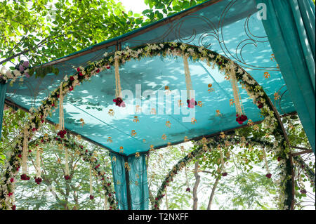 Licht durch die Bäume beleuchtet ein Vordach an einer Hochzeit in Indien Stockfoto