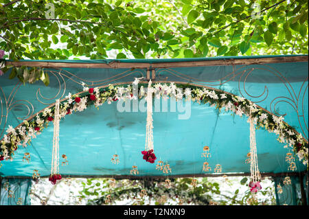 Licht durch die Bäume beleuchtet ein Vordach an einer Hochzeit in Indien Stockfoto