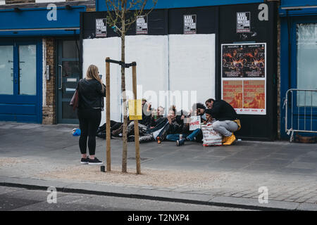 London, UK - März 23,2019: Frau unter Foto von Punks posieren für ein Foto auf einer Straße in Camden Town, London, einem Gebiet, berühmt für seine Markt- und nightli Stockfoto