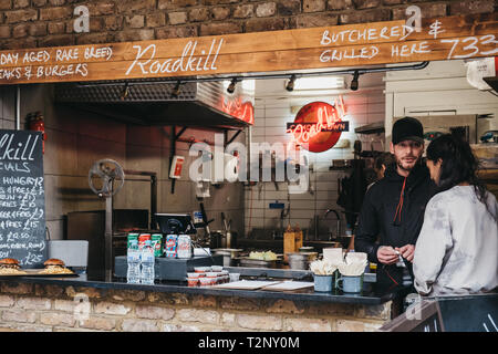 London, UK - März 23,2019: Das Personal an der Roadkill Street Food stand in Camden Market. Mit 16 Ständen im Jahr 1974 gestartet, Camden Market ist einer der Busi Stockfoto