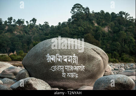 Eine tibetische Mantra ist auf einem riesigen Felsblock in einem Flussbett geschnitzt, unter Dharamshala, Indien: Die Heimat im Exil des Dalai Lama und Tausende von Tibetern. Stockfoto