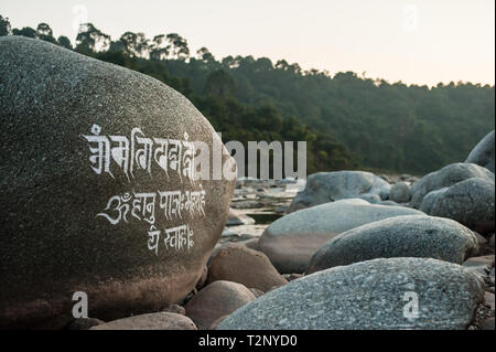 Eine tibetische Mantra ist auf einem riesigen Felsblock in einem Flussbett geschnitzt, unter Dharamshala, Indien: Die Heimat im Exil des Dalai Lama und Tausende von Tibetern. Stockfoto