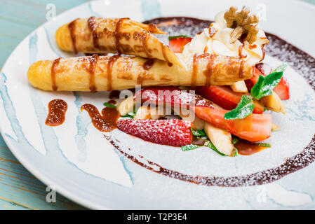 Eis Dessert mit Waffeln und Erdbeeren mit Zucker Pulver auf weißem Blech abgedeckt. Selektiver Fokus Stockfoto