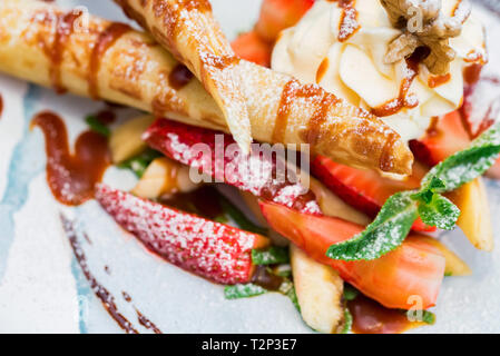 Eis Dessert mit Waffeln und Erdbeeren mit Zucker Pulver auf weißem Blech abgedeckt. Selektiver Fokus Stockfoto