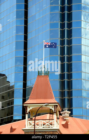 Australische Flagge am Fahnenmast auf dem Dach von einem altmodischen Gebäude vor einem Bürogebäude, Perth, Australien Stockfoto