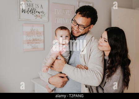 Paar mit Baby im Kinderzimmer Stockfoto