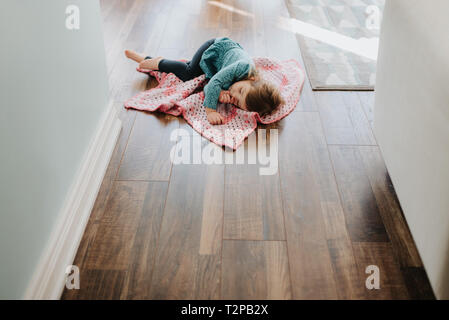 Weibliche Toddler schlafend auf Sicherheit Decke im Flur Stockfoto