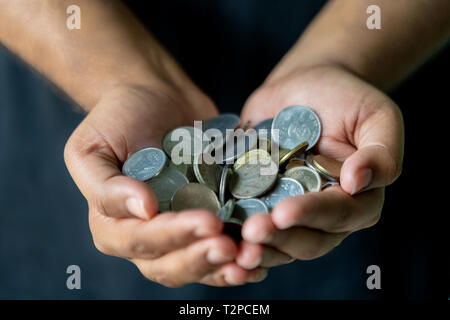 Münzen in den Händen. Geld sparen. Indische Münzen, die für den Hintergrund. Stockfoto