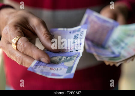 Indische männliche Hand Geld geben, von hundert Rupien Hinweis. Cash Konzept für Hintergrund. Stockfoto