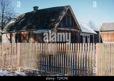 Alte hölzerne Scheune behinf einen Zaun in der Wintersaison Stockfoto