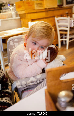 Baby Mädchen mit Puppe kuscheln eine flauschige Hund Stockfoto