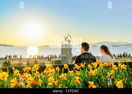 Narzissen, Sonnenuhr, Leute genießen Frühling Tag am Strand, English Bay, Vancouver, British Columbia, Kanada Stockfoto